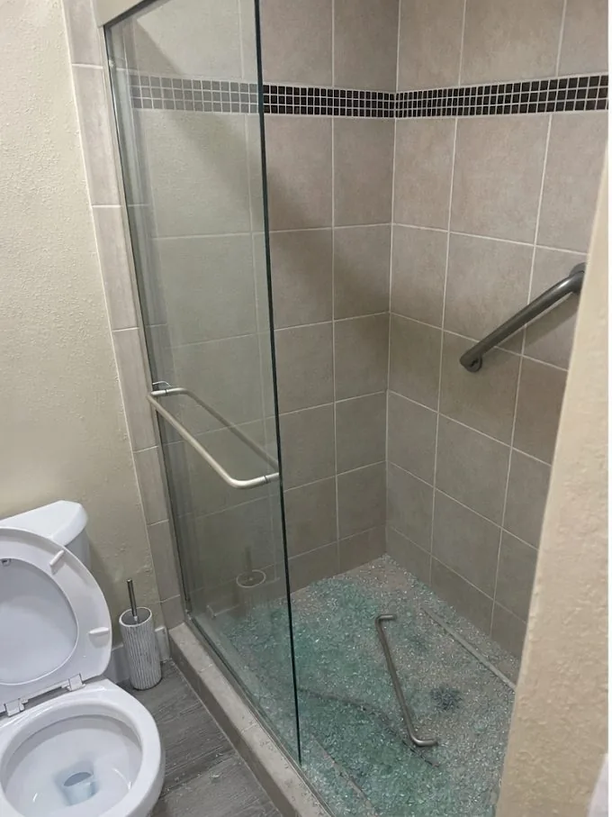 Shower with shattered glass door, before