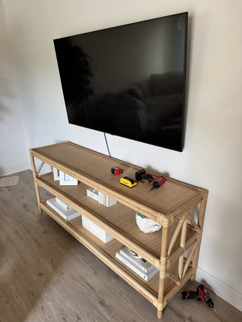 TV wall-mounted above a rattan console in Newport Beach, October 2026
